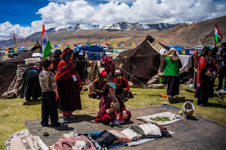 Changpa women in traditional dress and turquoise headdresses beside yak-hair tents at the Changthang festival