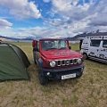 Pannu and Shubhu's van HOME parked beside a red Suzuki Jimny and a tent at Tso Moriri, Ladakh